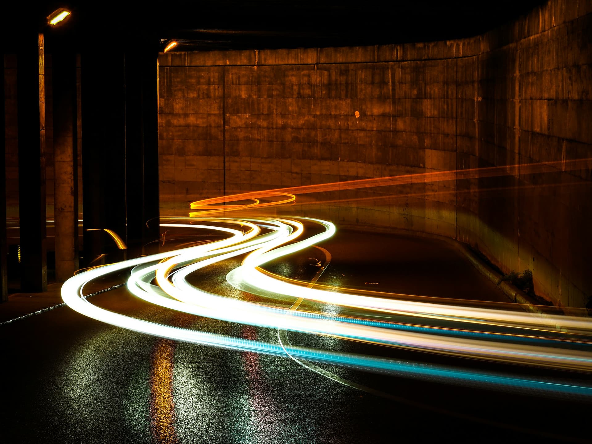Time-lapse photo of a city street at night, with headlights drawn into long streaks of light